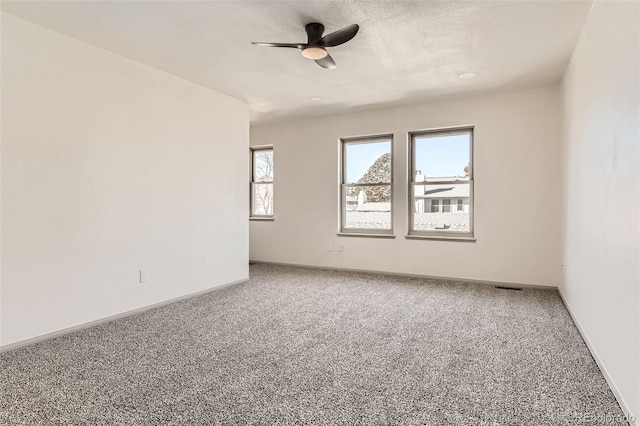 carpeted spare room with ceiling fan