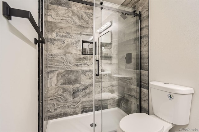 bathroom featuring an enclosed shower and toilet