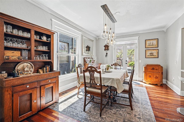 dining area featuring french doors, ornamental molding, baseboards, and hardwood / wood-style flooring