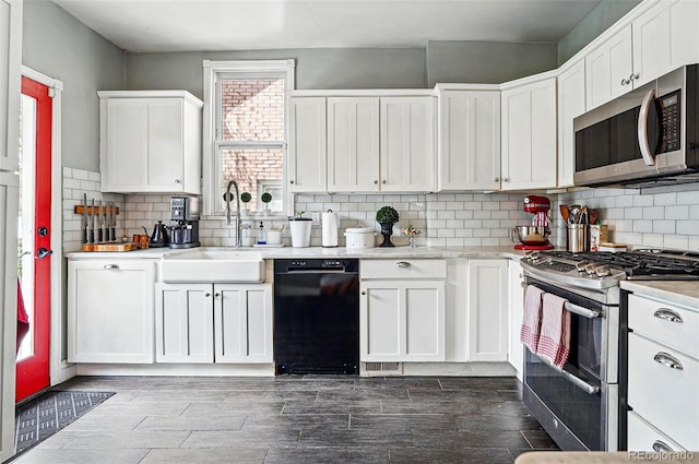 kitchen featuring light countertops, stainless steel appliances, white cabinetry, and a sink