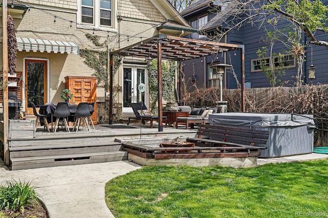 back of property with a hot tub, a pergola, fence, and a deck