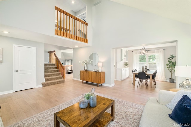 16438 E Prentice Cir, Centennial, CO 80015 - living area with high vaulted ceiling, light wood finished floors, stairs, a chandelier, and recessed lighting