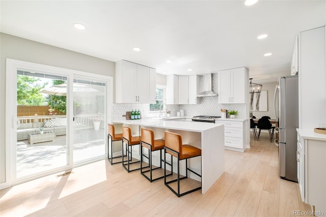 16438 E Prentice Cir, Centennial, CO 80015 - kitchen with wall chimney exhaust hood, freestanding refrigerator, a kitchen bar, backsplash, and recessed lighting