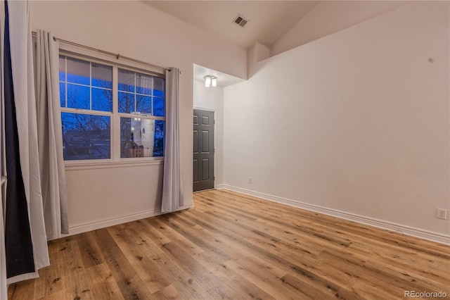 unfurnished room with lofted ceiling and light hardwood / wood-style flooring