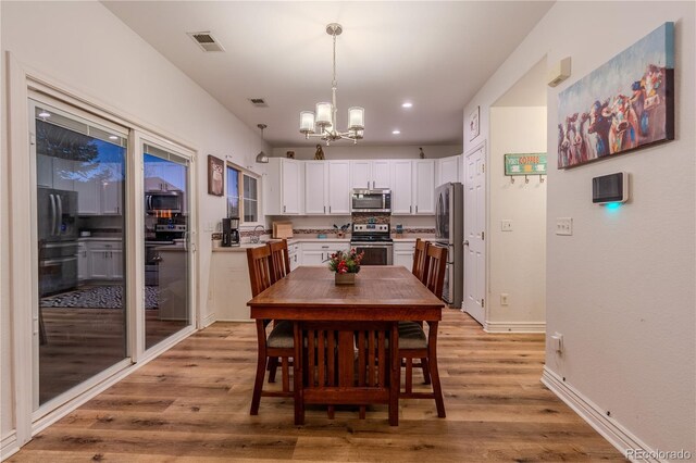 dining room featuring a notable chandelier, light wood-type flooring, and sink