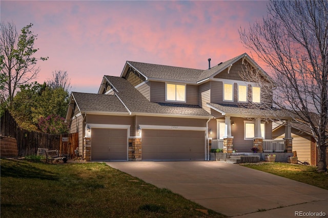 craftsman-style house featuring covered porch, concrete driveway, roof with shingles, and a front yard