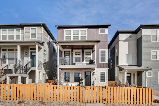 multi unit property featuring board and batten siding and a fenced front yard