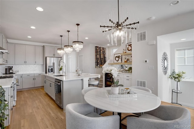 kitchen with appliances with stainless steel finishes, visible vents, light countertops, and a sink