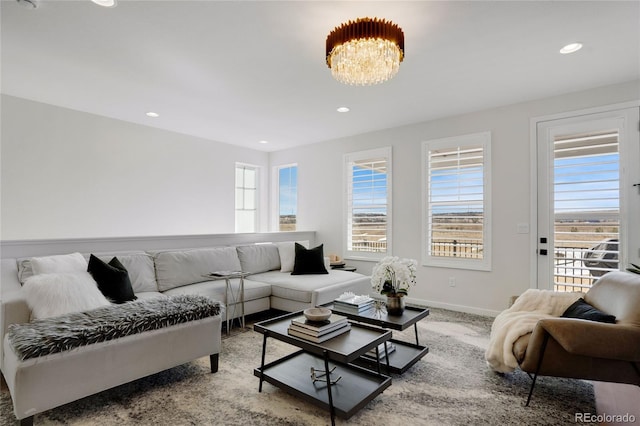 living area featuring baseboards, recessed lighting, a notable chandelier, and carpet flooring