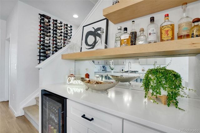 bar featuring beverage cooler, recessed lighting, lofted ceiling, light wood-type flooring, and bar area