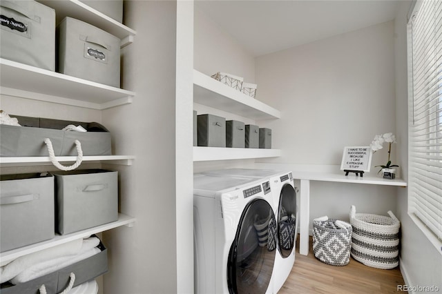 washroom featuring laundry area, washing machine and dryer, and wood finished floors