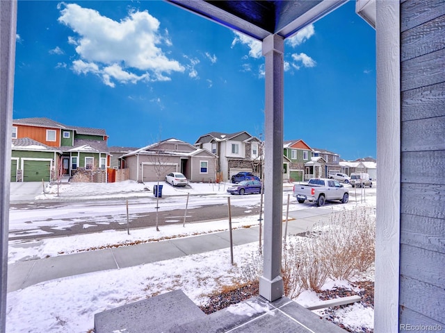 snow covered patio featuring a residential view