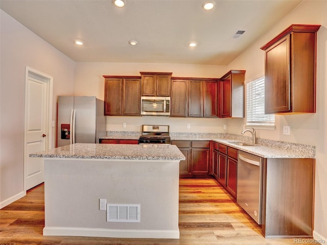 kitchen with a sink, visible vents, light wood-type flooring, and appliances with stainless steel finishes