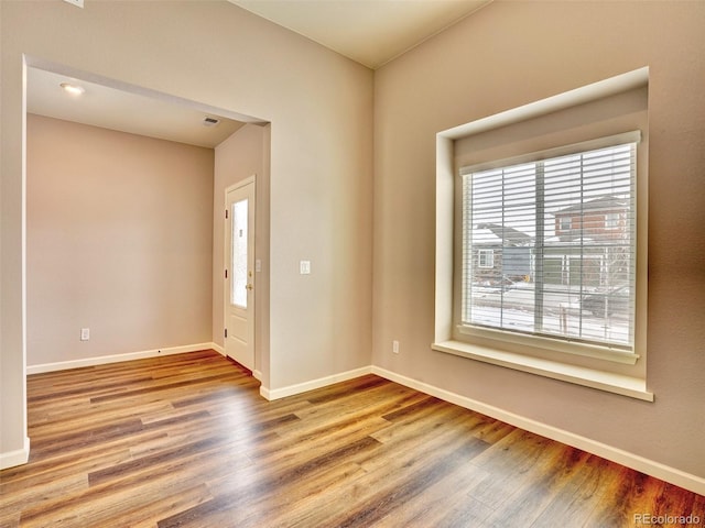 empty room featuring visible vents, baseboards, and wood finished floors