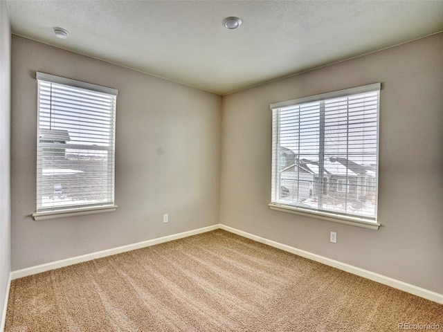 carpeted spare room with baseboards