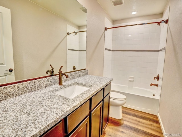 bathroom with visible vents, toilet, wood finished floors, shower / bath combination, and vanity