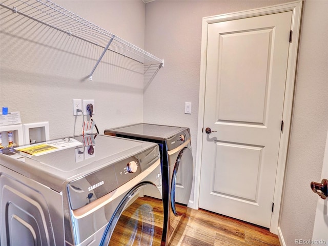 laundry area with wood finished floors, laundry area, and washing machine and clothes dryer