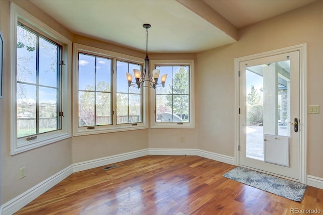 14993 W 55th Dr, Golden, CO 80403 - unfurnished dining area featuring a chandelier, wood finished floors, and baseboards