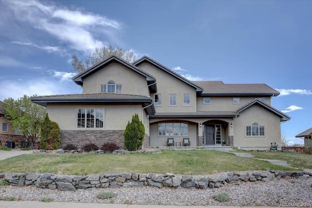 14993 W 55th Dr, Golden, CO 80403 - traditional-style house featuring stucco siding, stone siding, covered porch, and a front lawn