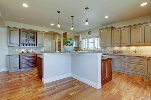 14993 W 55th Dr, Golden, CO 80403 - kitchen with backsplash, arched walkways, light wood-style floors, recessed lighting, and pendant lighting