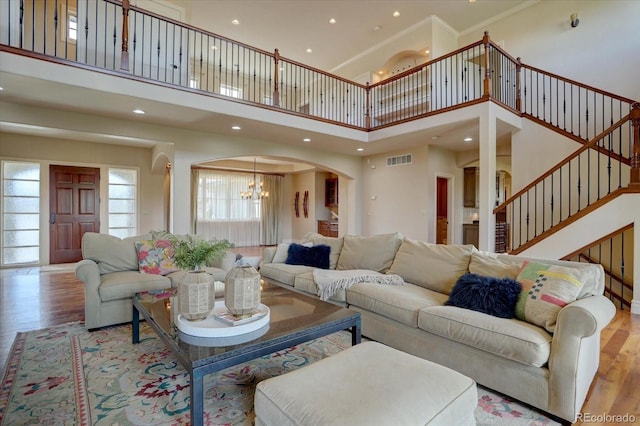 14993 W 55th Dr, Golden, CO 80403 - living area featuring a chandelier, a towering ceiling, wood finished floors, ornamental molding, and stairway