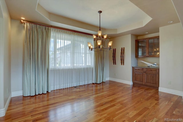 14993 W 55th Dr, Golden, CO 80403 - unfurnished dining area with a chandelier, a raised ceiling, light wood-type flooring, baseboards, and recessed lighting