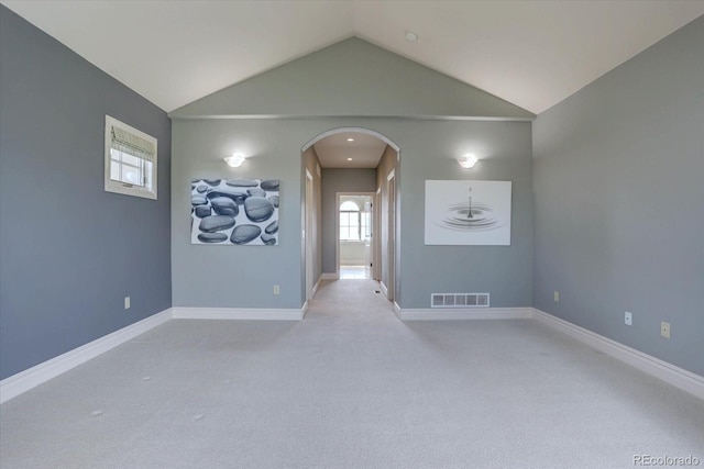 14993 W 55th Dr, Golden, CO 80403 - empty room featuring arched walkways, vaulted ceiling, carpet floors, and baseboards