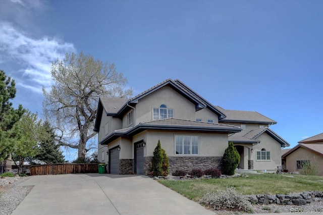 14993 W 55th Dr, Golden, CO 80403 - view of front of home with stone siding, driveway, stucco siding, and a garage