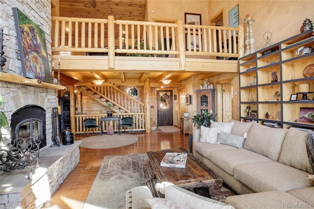 11450 Marks Dr, Conifer, CO 80433 - living room with a fireplace, a towering ceiling, wood finished floors, and wood walls