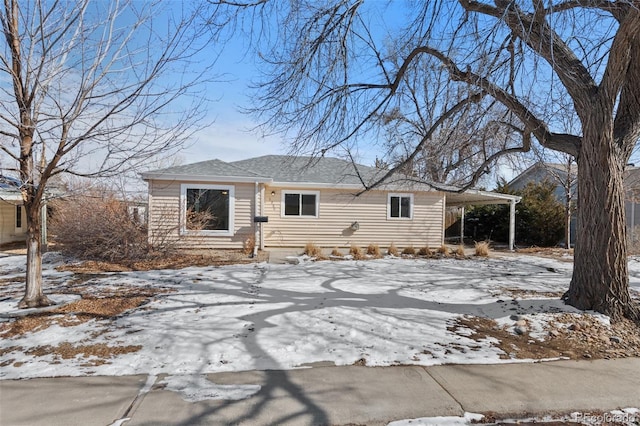 view of front facade featuring an attached carport and roof with shingles