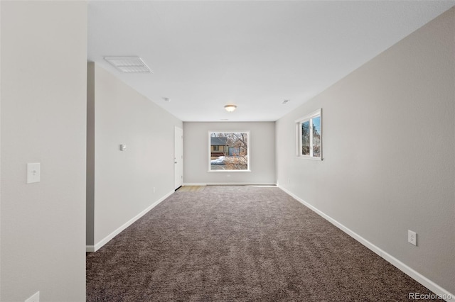 carpeted spare room featuring visible vents and baseboards