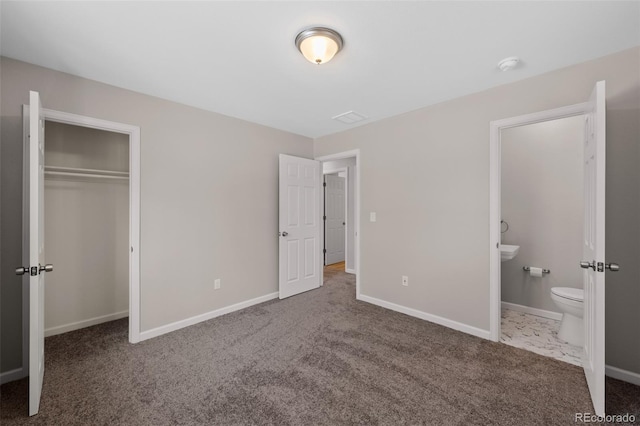 unfurnished bedroom with dark colored carpet, a closet, and baseboards