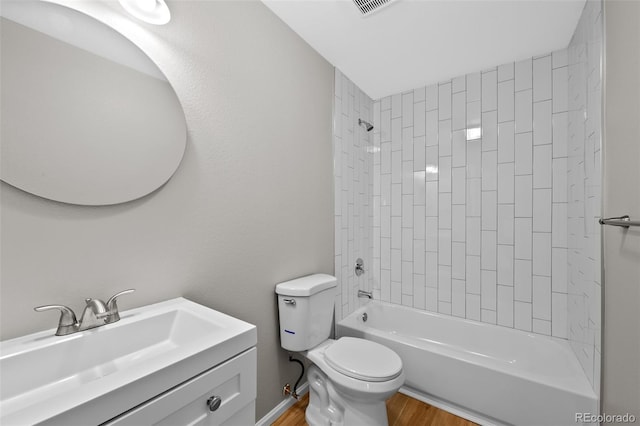 bathroom featuring visible vents, toilet, wood finished floors, vanity, and washtub / shower combination