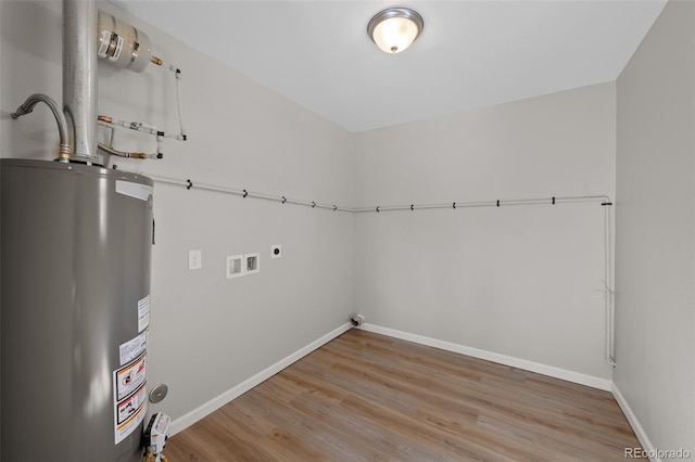 laundry area with laundry area, washer hookup, wood finished floors, baseboards, and water heater