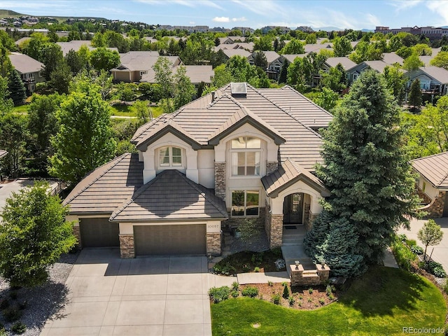 10057 S Shadow Hill Dr, Lone Tree, CO 80124 - tudor house featuring stone siding, a garage, driveway, and a tile roof