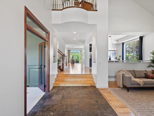 10057 S Shadow Hill Dr, Lone Tree, CO 80124 - entryway featuring stone finish flooring, a chandelier, stairs, a high ceiling, and baseboards