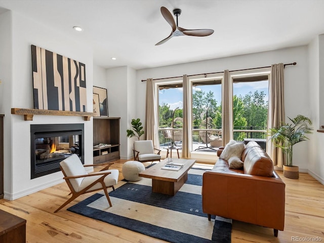 10057 S Shadow Hill Dr, Lone Tree, CO 80124 - living area with wood finished floors, a glass covered fireplace, a ceiling fan, baseboards, and recessed lighting