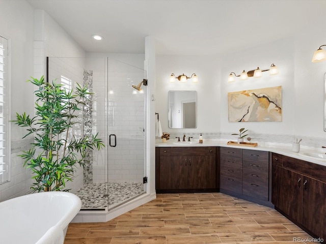 10057 S Shadow Hill Dr, Lone Tree, CO 80124 - full bath featuring double vanity, a shower stall, a freestanding tub, wood finished floors, and recessed lighting