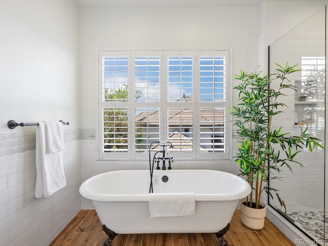 10057 S Shadow Hill Dr, Lone Tree, CO 80124 - bathroom with tile walls, wood finished floors, a freestanding bath, and wainscoting