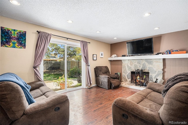 living room with a fireplace, hardwood / wood-style floors, and a textured ceiling