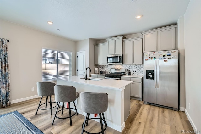 kitchen featuring a center island with sink, gray cabinetry, sink, and appliances with stainless steel finishes