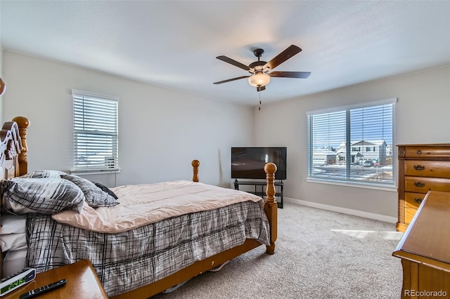 carpeted bedroom featuring ceiling fan and multiple windows