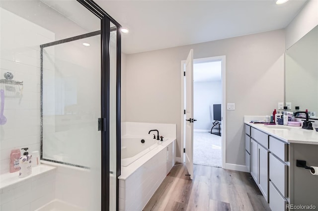 bathroom featuring hardwood / wood-style floors, vanity, and independent shower and bath