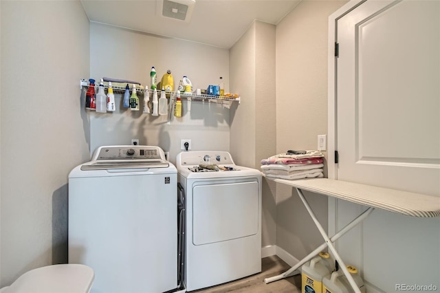 laundry room featuring separate washer and dryer and light hardwood / wood-style flooring