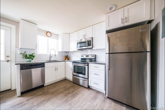 kitchen featuring stainless steel appliances, a sink, and white cabinetry