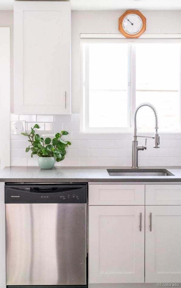 kitchen with dishwasher, a sink, white cabinetry, and tasteful backsplash