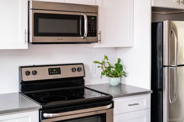 kitchen featuring stainless steel appliances, white cabinets, and tasteful backsplash