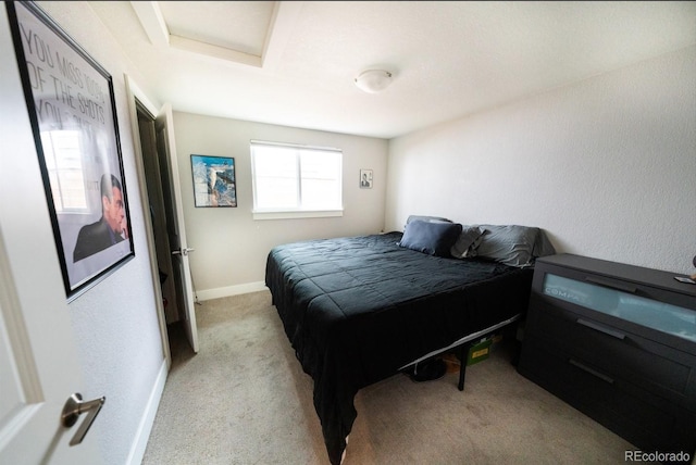 bedroom featuring attic access, light colored carpet, and baseboards