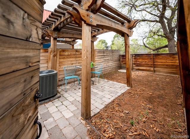 view of patio / terrace with central AC, a fenced backyard, and a pergola