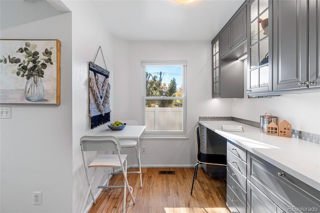 interior space with built in desk and light hardwood / wood-style flooring